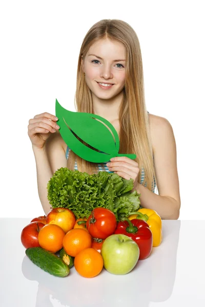 Kvinna sitter vid bordet med vegetabiliska — Stockfoto