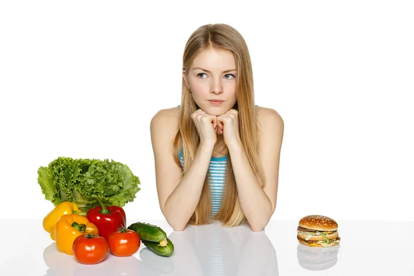 Mujer tomando decisiones entre la comida saludable y la comida rápida — Foto de Stock