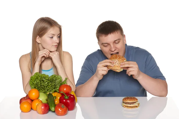 Mulher olhando seu boyfreind comer fast food — Fotografia de Stock