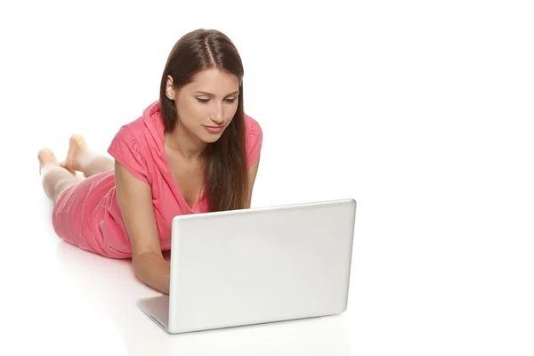 Woman using laptop lying on the floor Royalty Free Stock Images