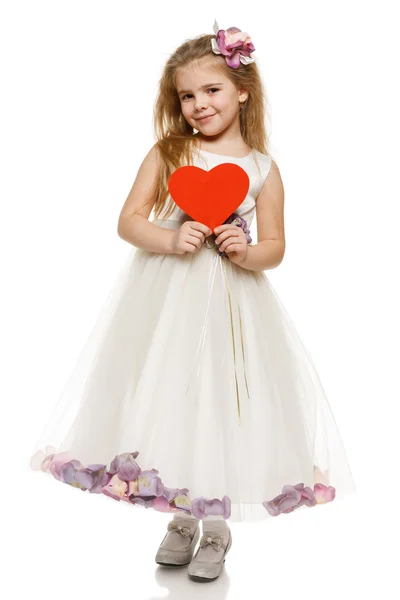 Girl in princess dress holding heart shape — Stock Photo, Image