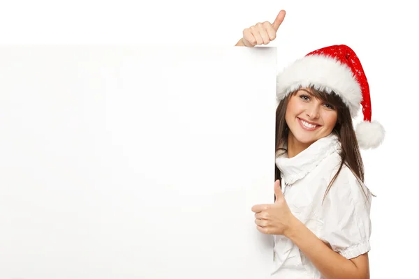 Girl in Santa hat holding blank banner and showing thumb up sign — Stock Photo, Image