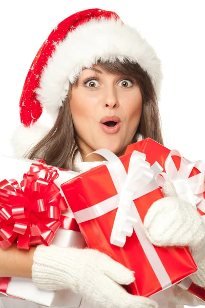 Mädchen mit Weihnachtsmütze, überrascht von vielen Weihnachtsgeschenken — Stockfoto