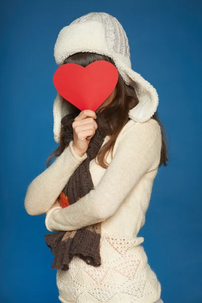 Winter girl holding heart shape in front of face — Stock Photo, Image