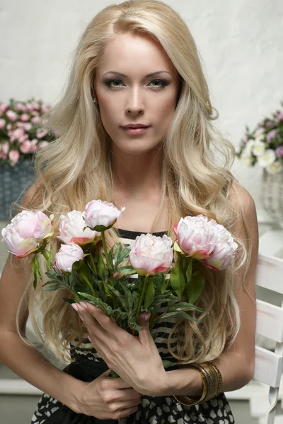 Fashion model posing with bunch of peonies — Stock Photo, Image
