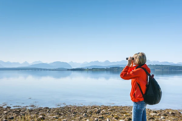 Touristin blickt durch Fernglas — Stockfoto