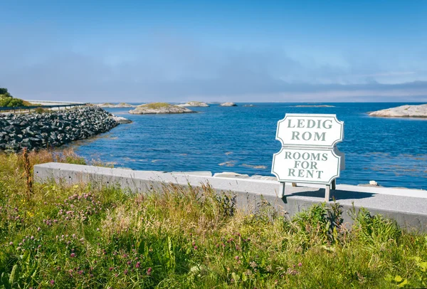 Rooms for rent sign against blue Atlantic ocean