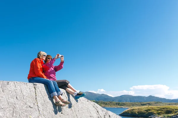 Two women taking photo of Norwegian landscape — Stock Photo, Image