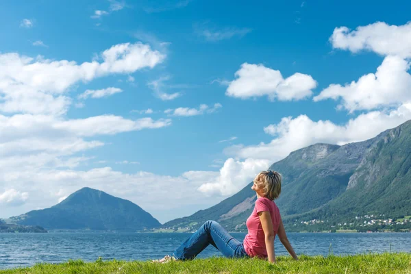 Femme relaxante jouissant à la côte du fjord — Photo