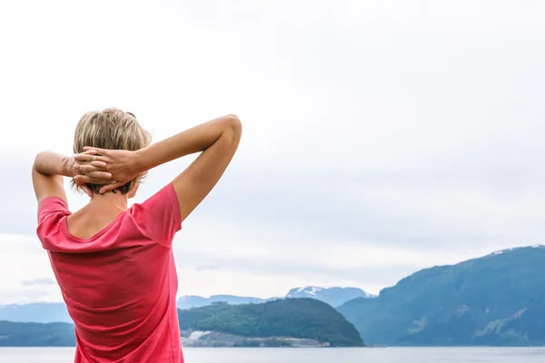 Vista posterior de una mujer disfrutando de una vista en el fiordo —  Fotos de Stock