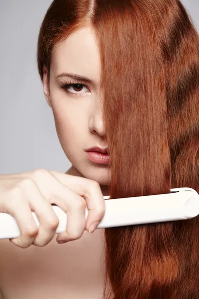 Vörös hajú nő, haj hajkiegyenesítő vasalók — Stock Fotó