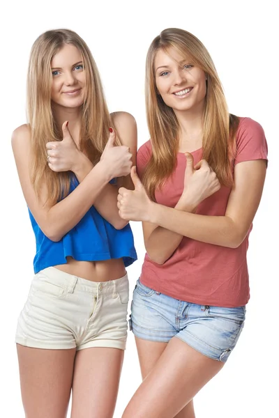 Happy two girl friends gesturing thumbs up — Stok Foto