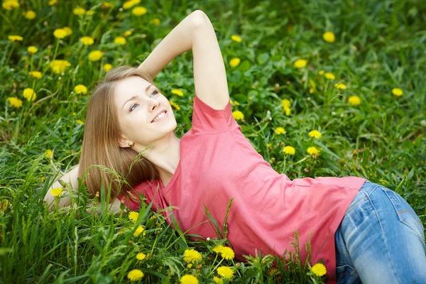 Primavera chica acostada en el campo de los dientes de león —  Fotos de Stock