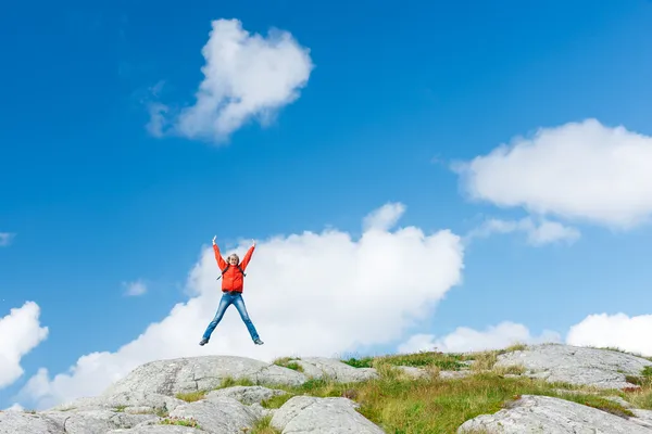 Woman hiker jumps on stones — Stock Photo, Image