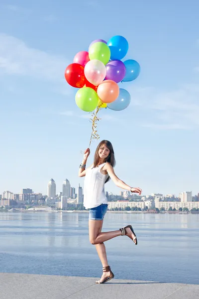 Šťastná mladá žena s barevnými balónky — Stock fotografie