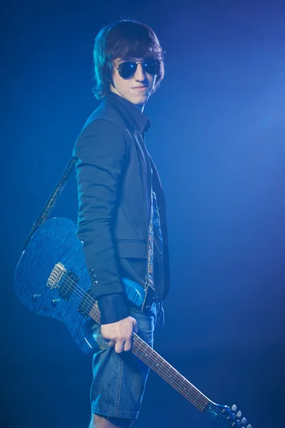 무대에서 연기에 서 있는 젊은 기타리스트 — 스톡 사진