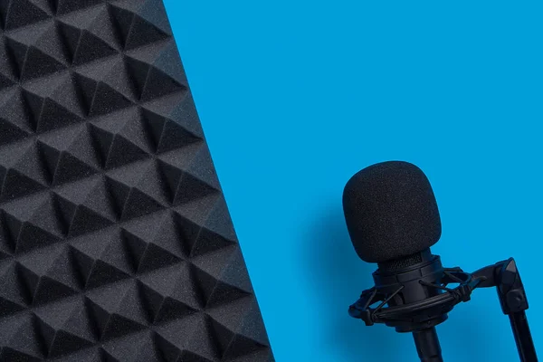 Colocación plana de micrófono y panel de espuma acústica, sobre fondo azul — Foto de Stock