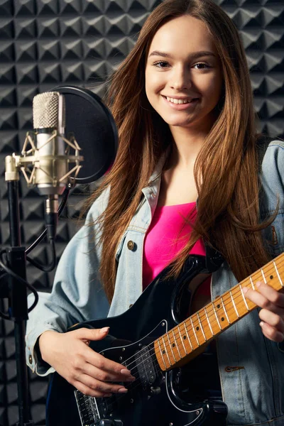 Girl musician in recording studio playing electric guitar — Stock Photo, Image