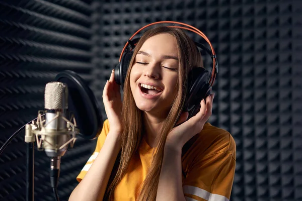 Mädchen Aufnahmestudio Singt Mit Mikrofon Kopfhörer Über Akustischem Absorberpaneel Hintergrund — Stockfoto