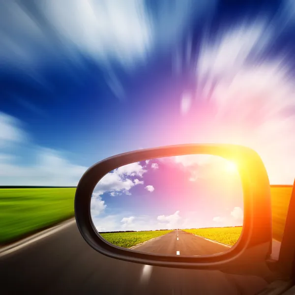 Espelho do carro com céu azul acima da estrada — Fotografia de Stock