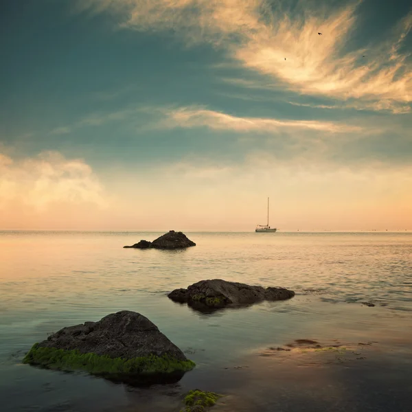 Meer und Segelboot am Horizont bei bewölktem Himmel — Stockfoto