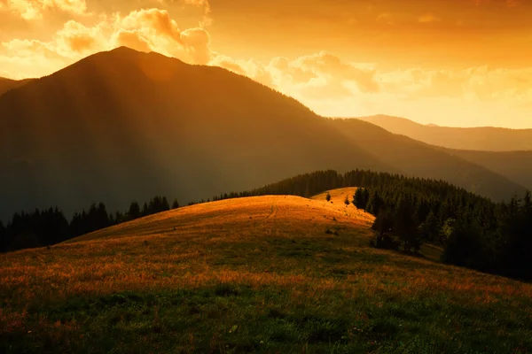 Güneş ışınları puslu tepelerin üstünde — Stok fotoğraf
