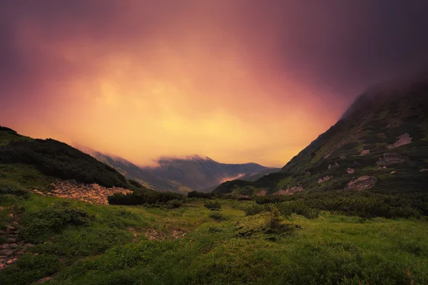 Verdi colline tra le nuvole dopo il tramonto — Foto Stock