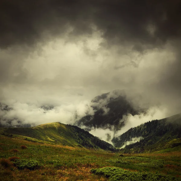 Nuvens escuras e nevoeiro sobre o vale da montanha — Fotografia de Stock