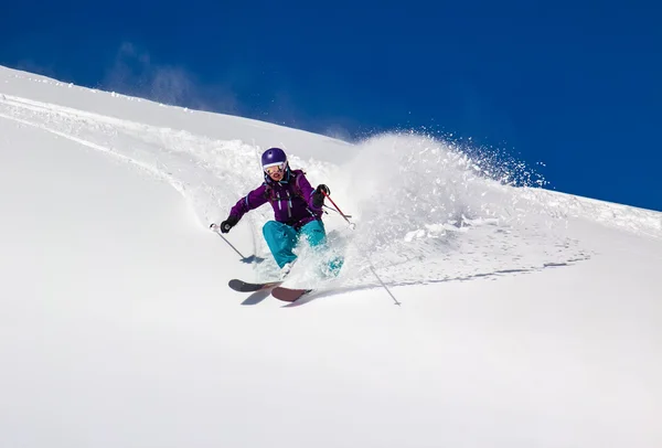 Vrouw skiër draait op een steile helling — Stockfoto