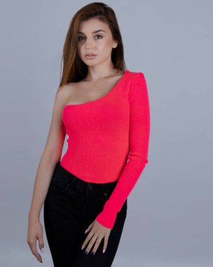 Stüdyoda pembe seksi bluzuyla poz veren kadın. 