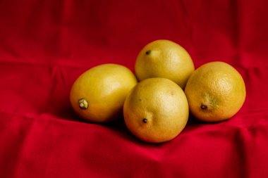 Kırmızı arkaplanda bir sürü limon var.