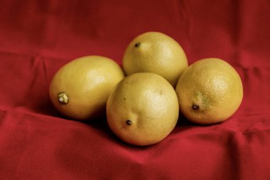 Kırmızı arkaplanda bir sürü limon var.