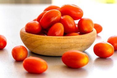 Kirazları, domatesleri küçük ahşap kaseye koy.