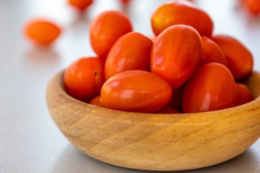 Kirazları, domatesleri küçük ahşap kaseye koy.