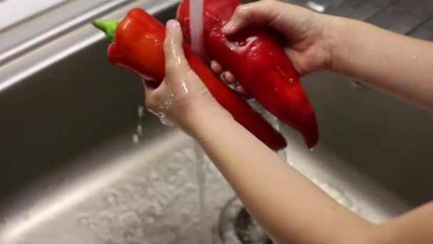 キッチンシンクで赤ピーマンを洗う子供は — ストック動画