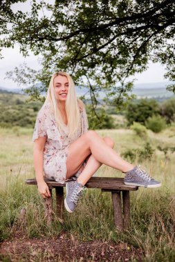 Yeşil çayırdaki yazlık elbiseli güzel kız.