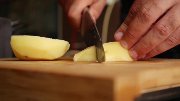 Mann Schneidet Geschälte Kartoffeln Hautnah Auf Holzbrett — Stockvideo