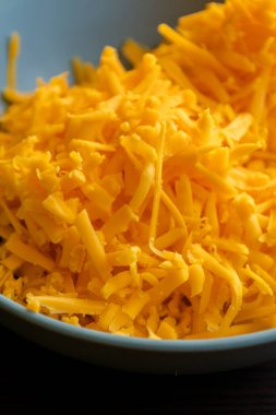 grated cheddar cheese on a plate on wood table