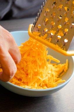 grated cheddar cheese on a plate on wood table