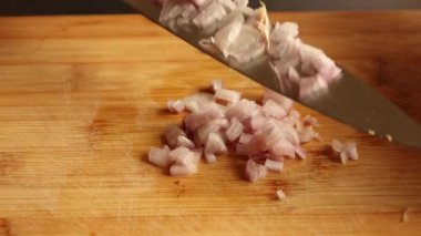cutting shallot on wooden chopping board