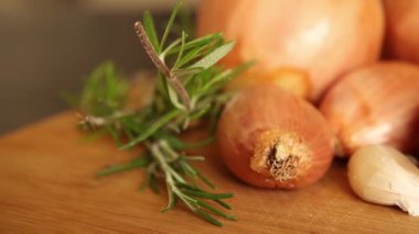 fresh raw onions, garlic, rosemary close up in wooden bowl