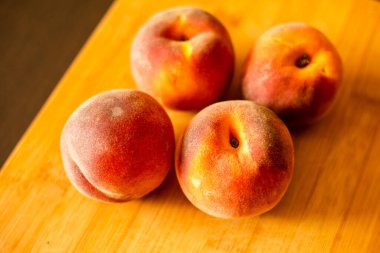 Ripe peaches on wooden board close up
