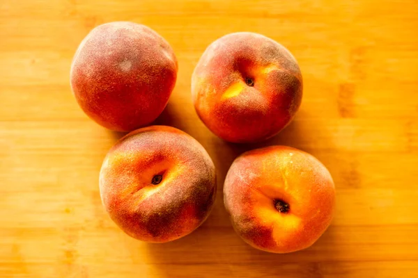 Ripe peaches on wooden board close up