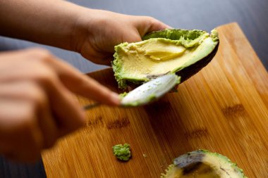 cutting avocado on wooden board close up at home