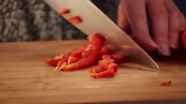 Kadın elleri evde kırmızı dolma biber kesiyor. Yakın çekim.