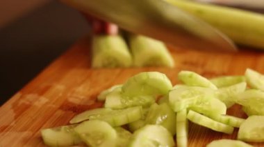 Salatalık kesen erkek elleri tahta tahtaya yakın durur.