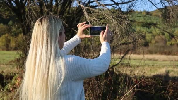 在自然界中使用手机拍照的女人 — 图库视频影像