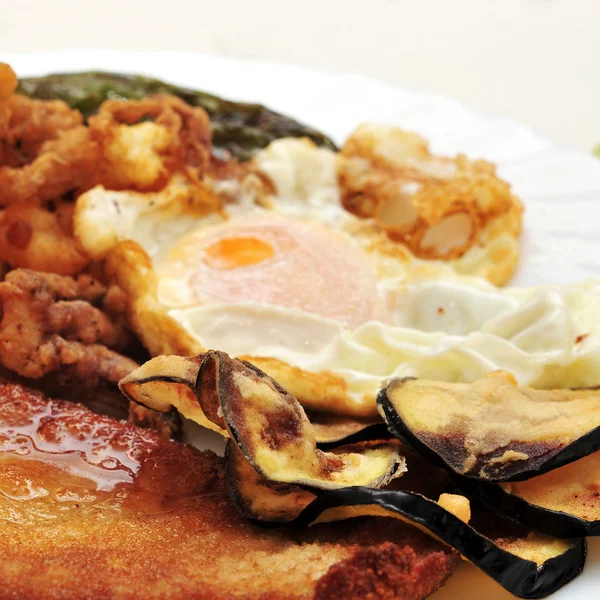 Combo platter with fried eggs, breaded chicken, battered eggplan — Stock Photo, Image