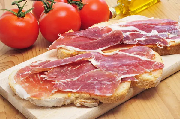 Brotscheiben mit Serrano-Schinken als Tapas serviert — Stockfoto