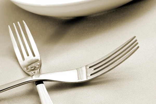 Forks and plates on a tablecloth — Stock Photo, Image